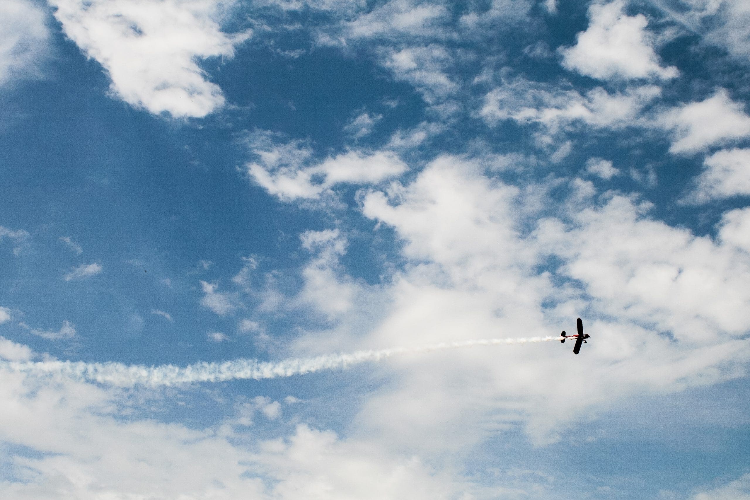 biplane in a blue sky with clouds
