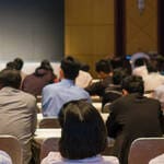 Group of people in an auditorium listening to a speaker for training